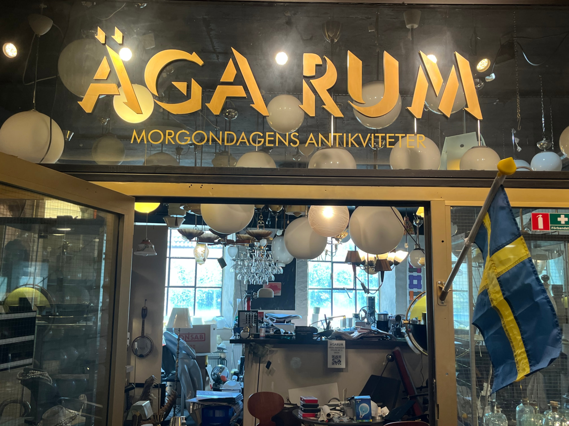 Butiksfasaden med skylten Äga rum – morgondagens antikviteter